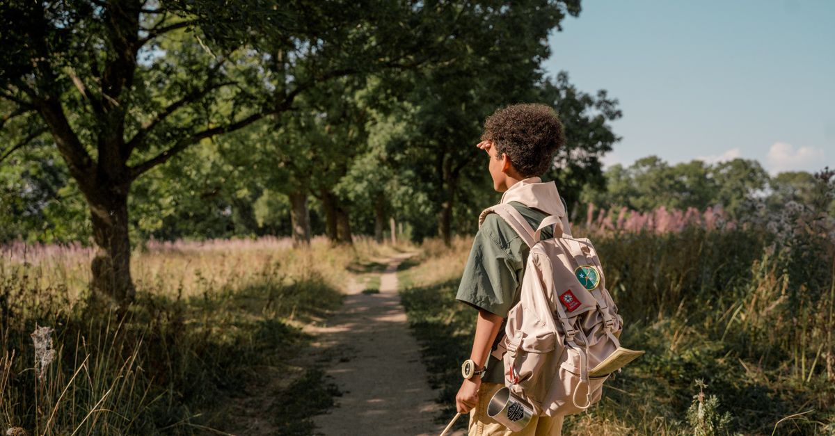 Sac de survie enfant porté par un enfant sur un sentier en forêt