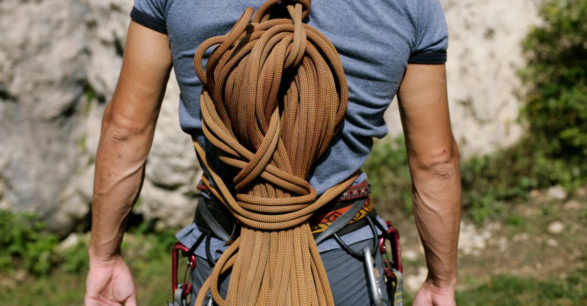 Hands tying a survival knot on a rope outdoors