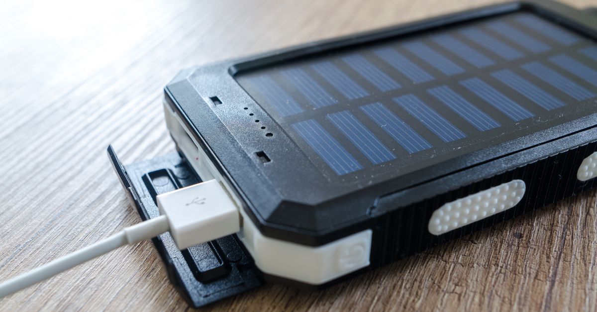 Panneau solaire portable camping posé au sol relié à une batterie externe