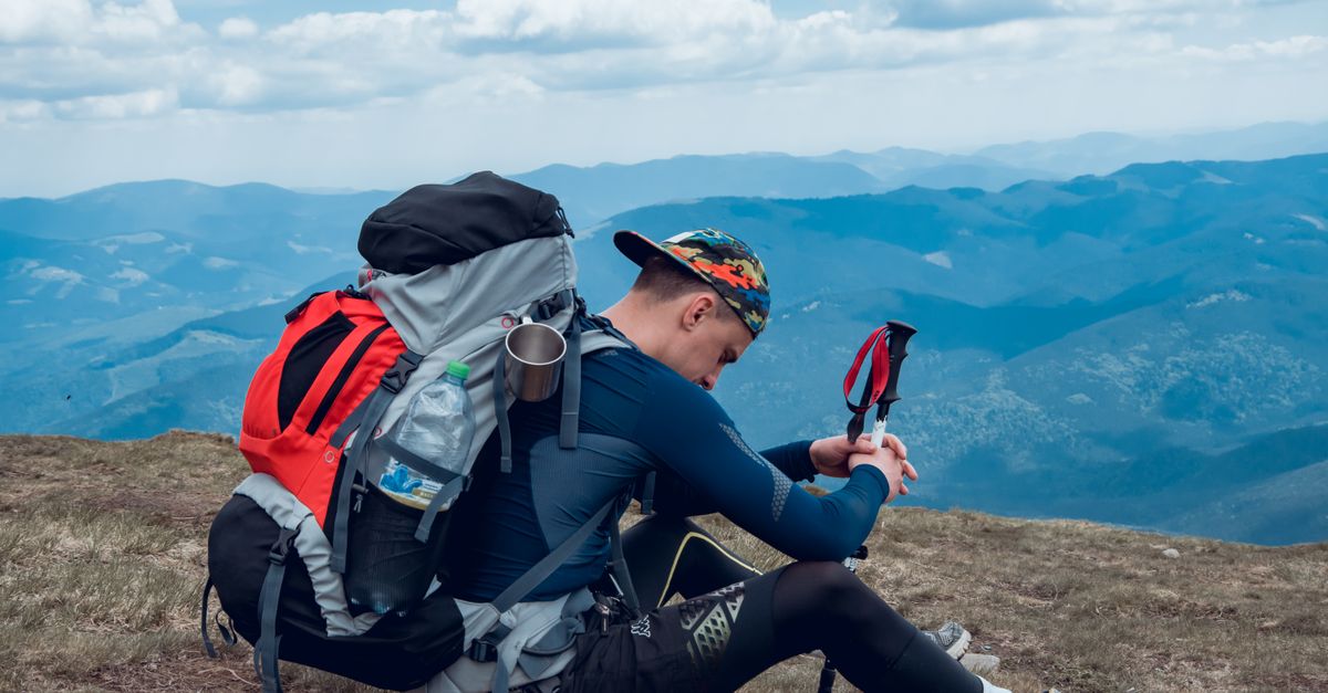 Randonneur qui rassure une personne en état de choc assise au sol en pleine nature
