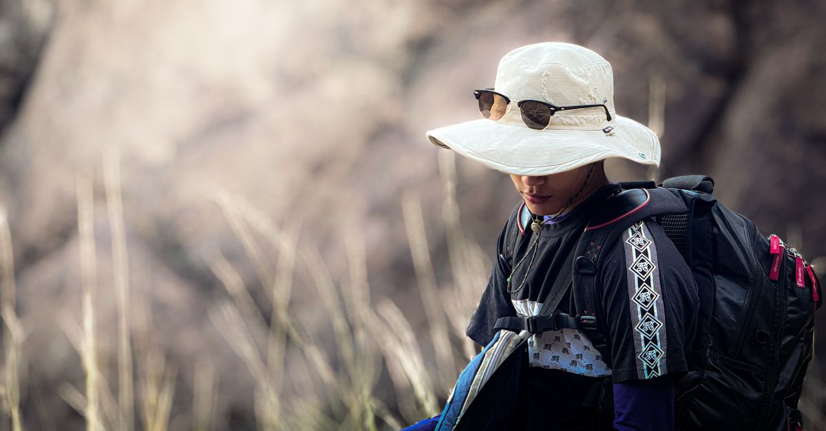 Surviving a heatwave, hiker wearing a wide sun hat outdoors