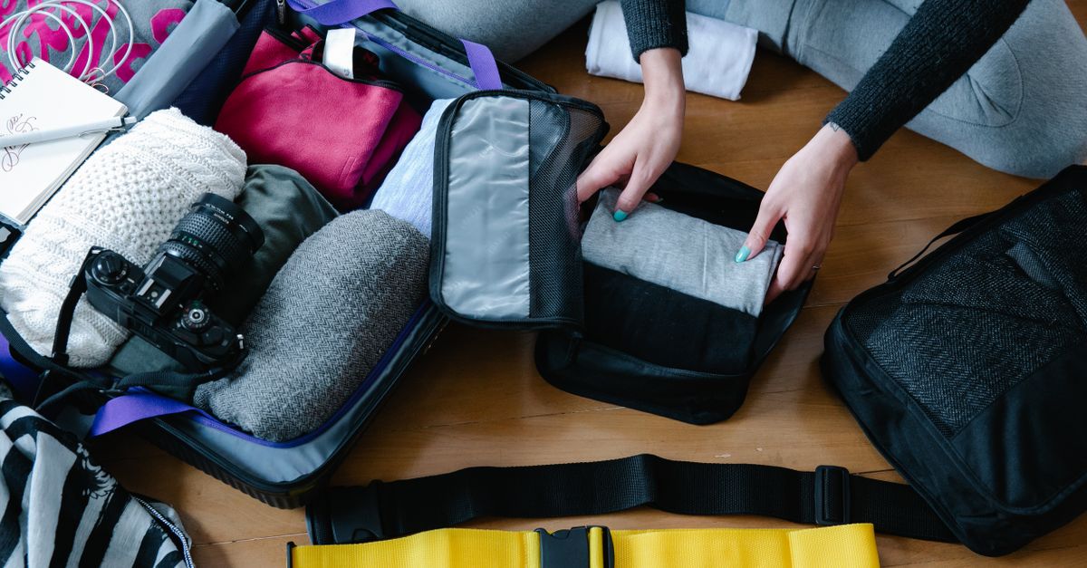 Military packing technique shown with rolled clothes packed inside an open backpack