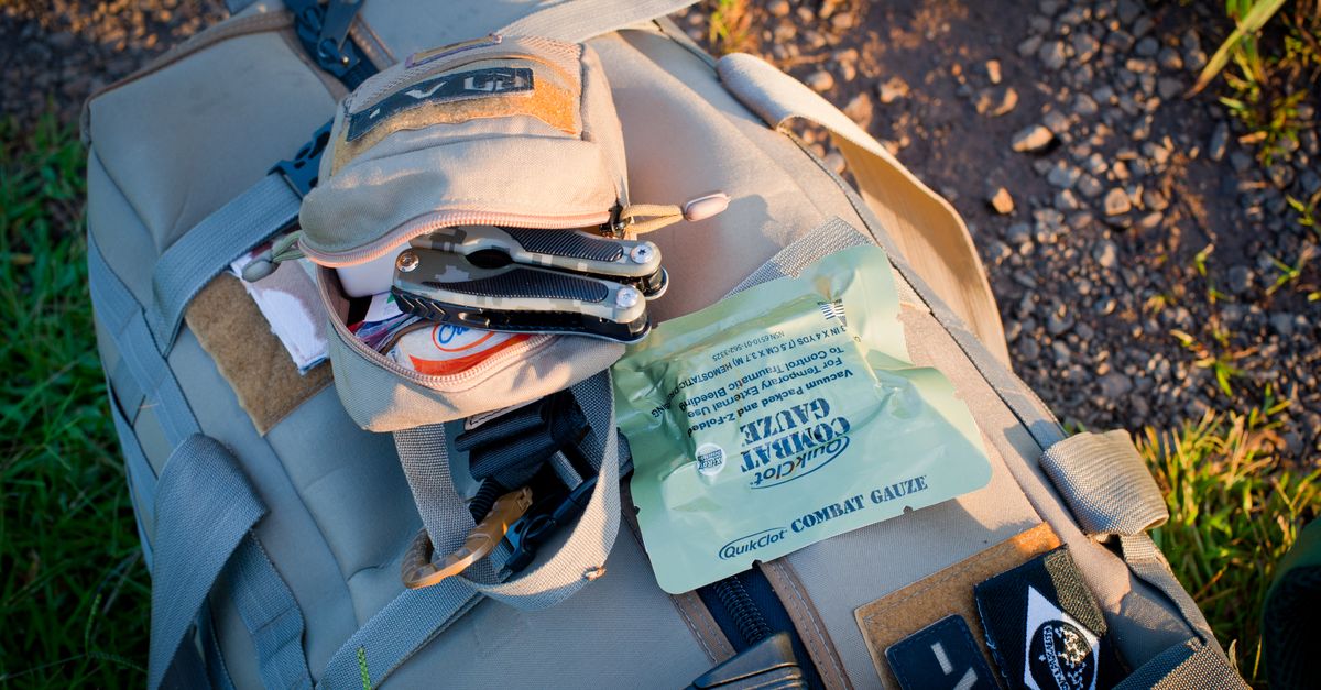 Trousse de secours ouverte avec pansements et compresses sur un sac à dos