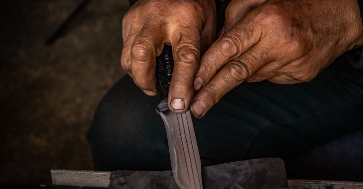 Affûter son couteau bushcraft, mains aiguisant une lame sur une pierre à eau