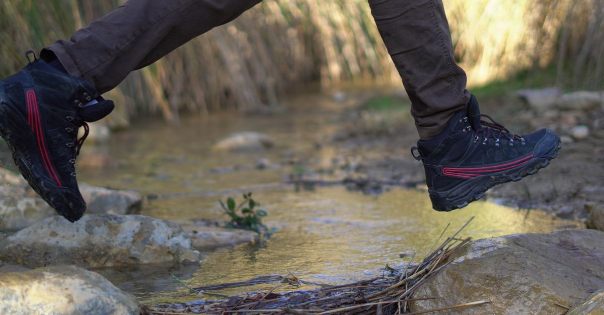 Se protéger des tiques, randonneur qui vérifie ses jambes sur un sentier forestier