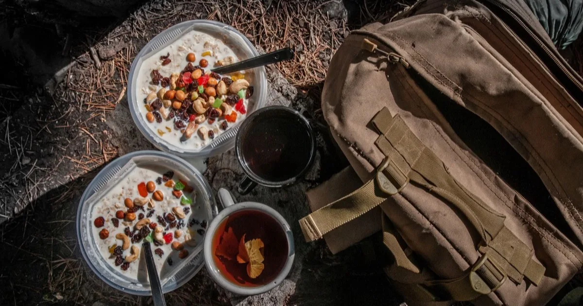 Snacks for a multi-day hike: dried fruit, nuts and tea by a backpack